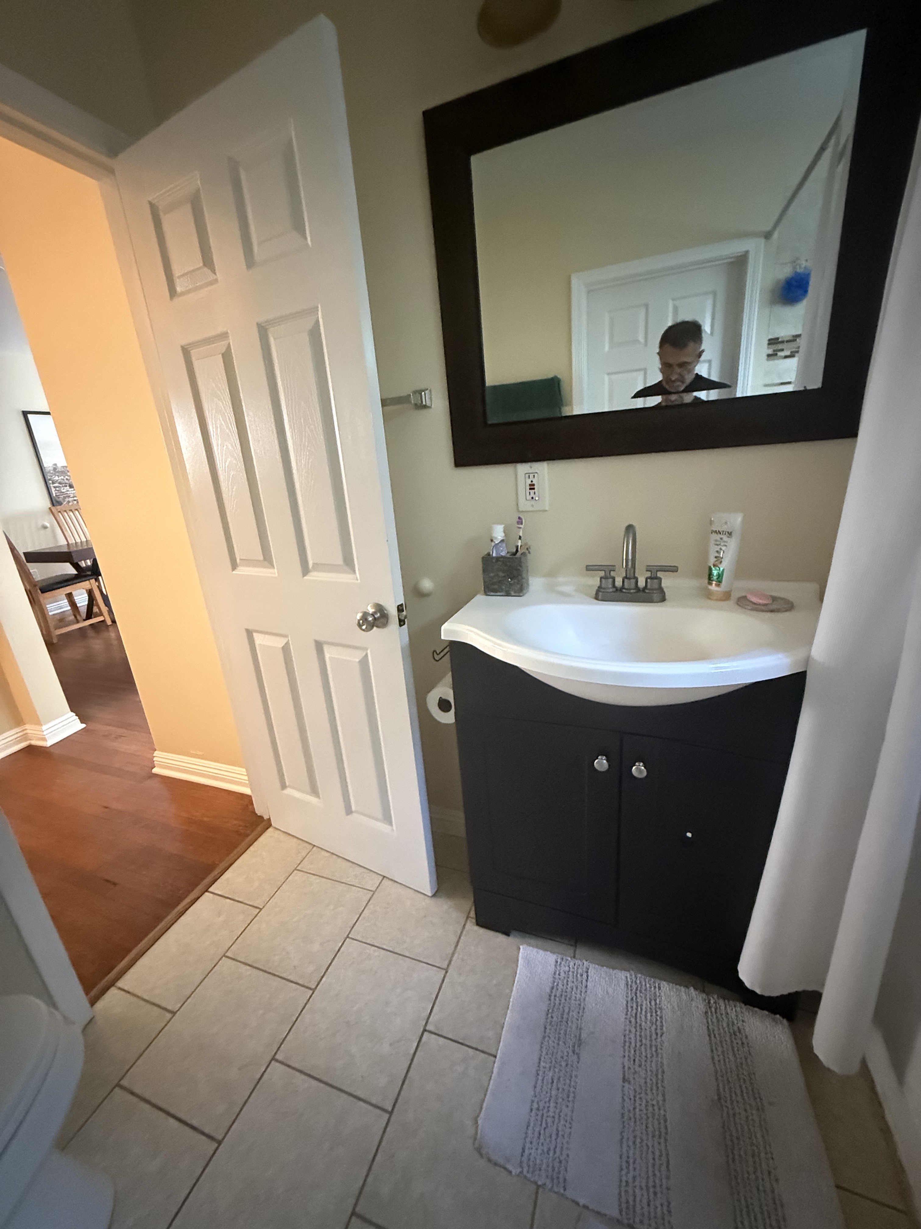 Shared bathroom vanity, tile floor, and tub