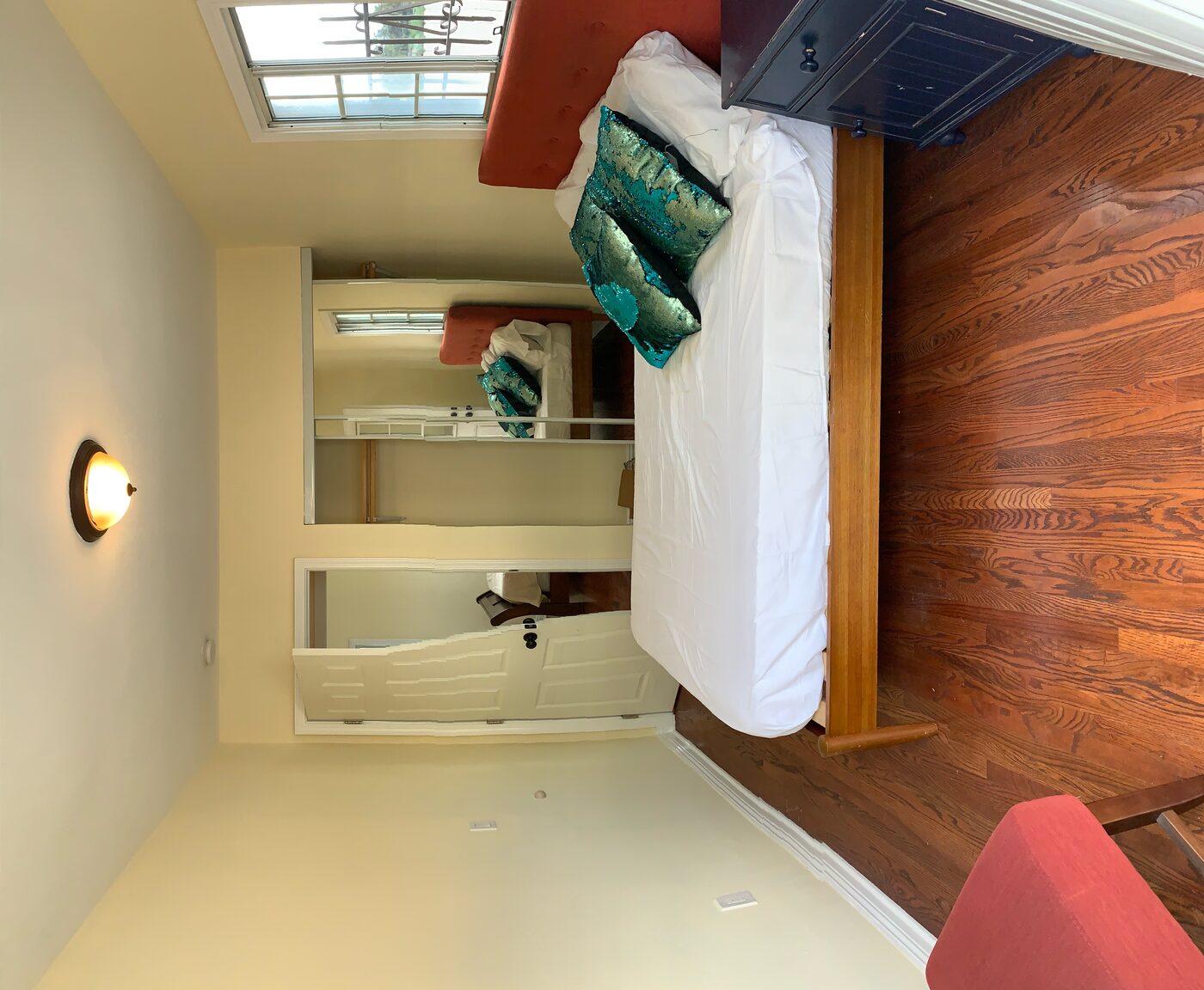 Junior bedroom with bed, mirrored closet, and hardwood floors